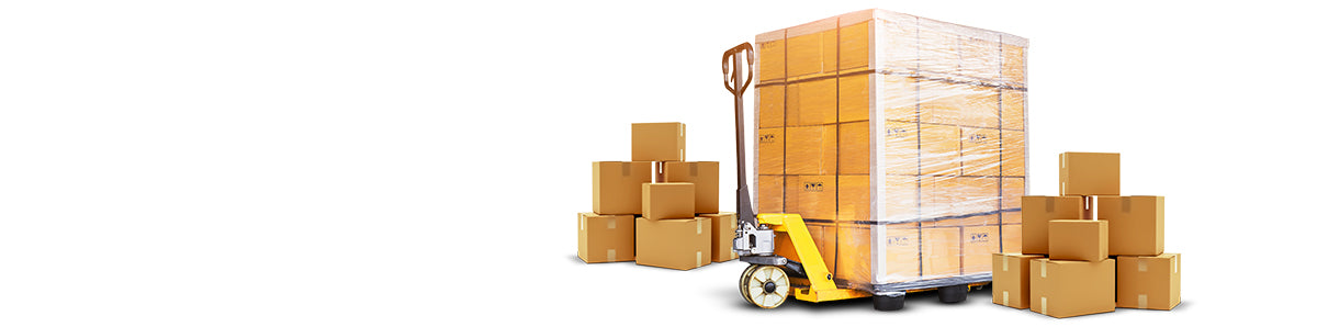 Pallet of cardboard boxes wrapped for freight shipping, surrounded by packages and a pallet jack.